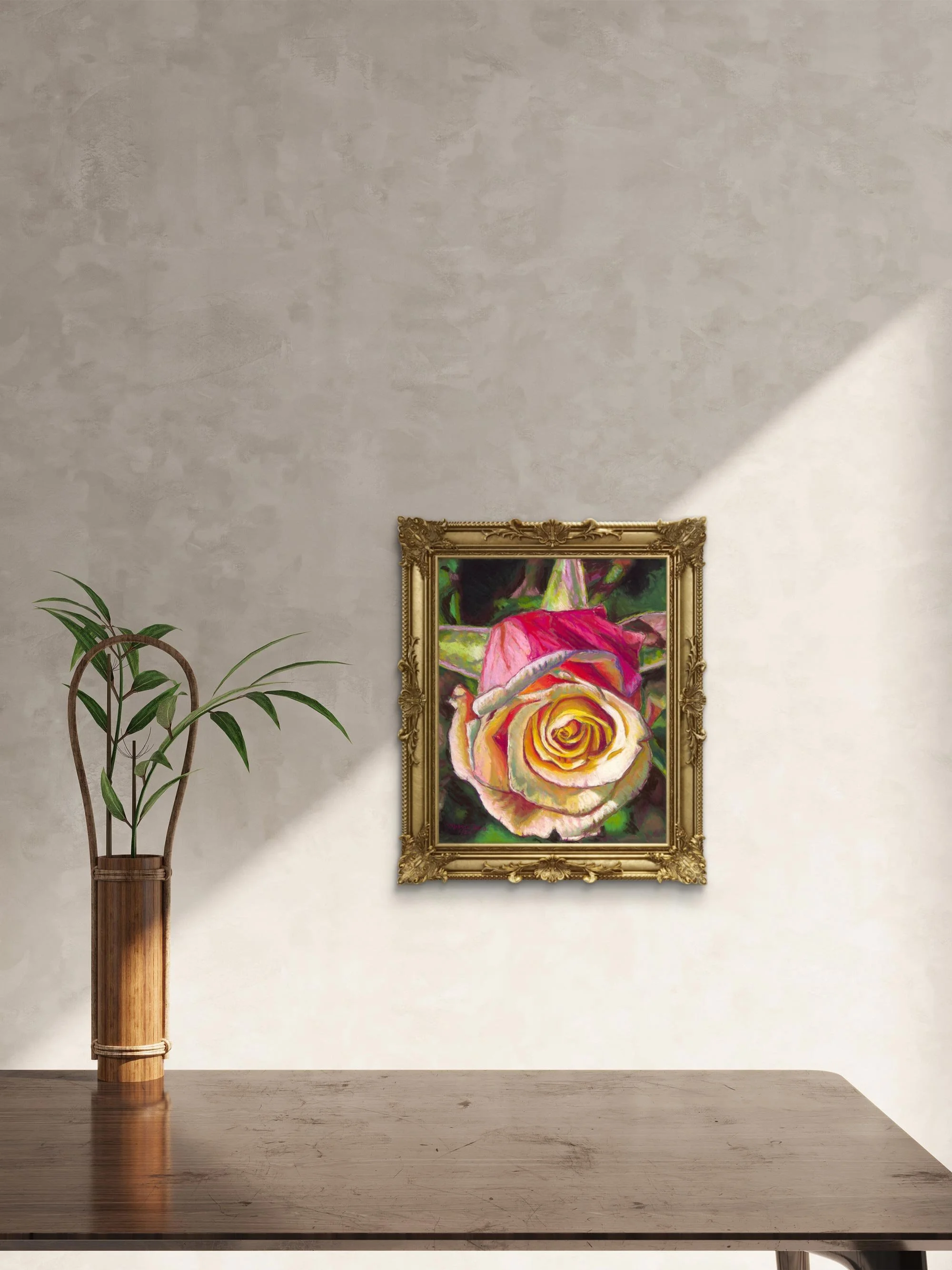 Gold-framed rose painting on a beige wall with sunlight and a plant in a brass vase
