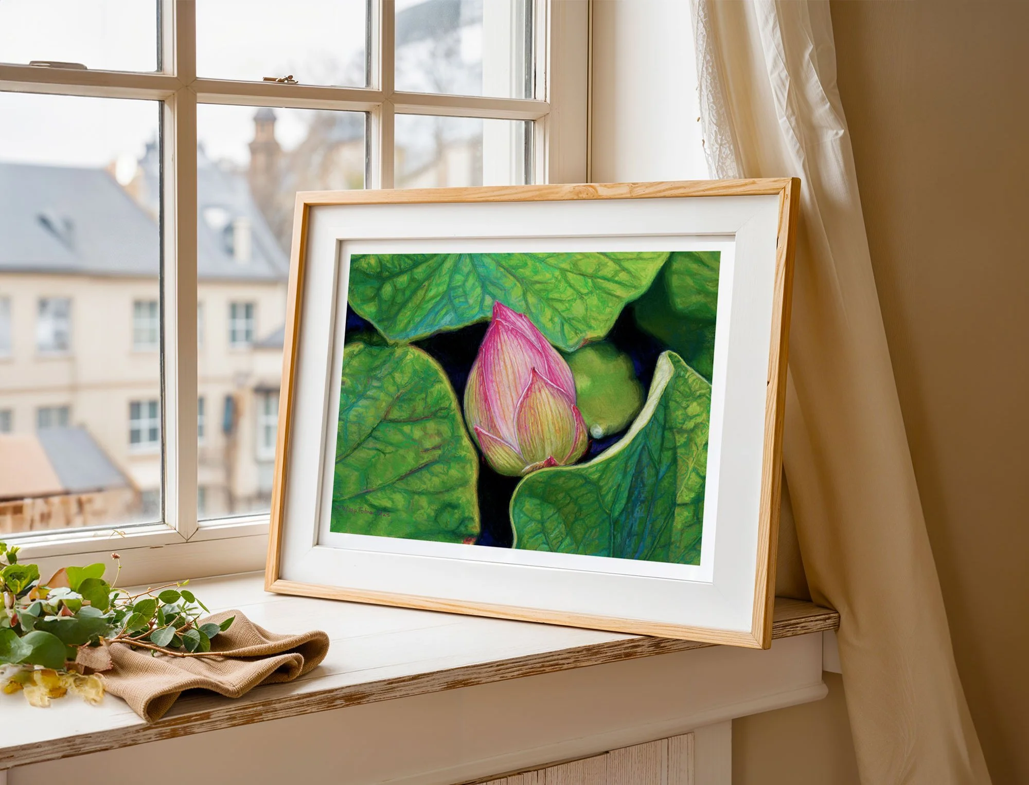 A framed horizontal print showing a pink lotus flower painting near window on bureau