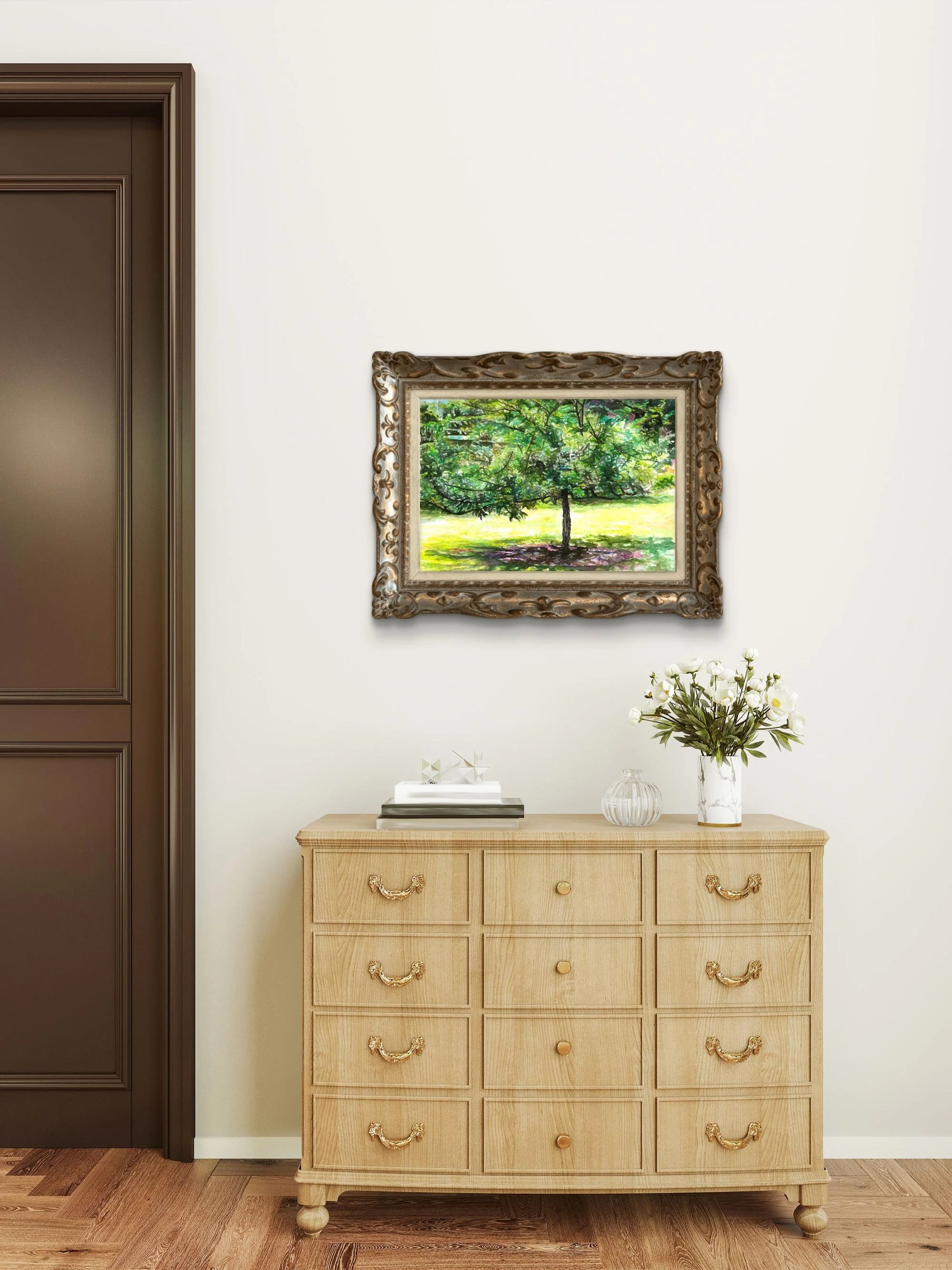 Crabapple tree watercolor in an ornate gold frame above a wood dresser with white flowers