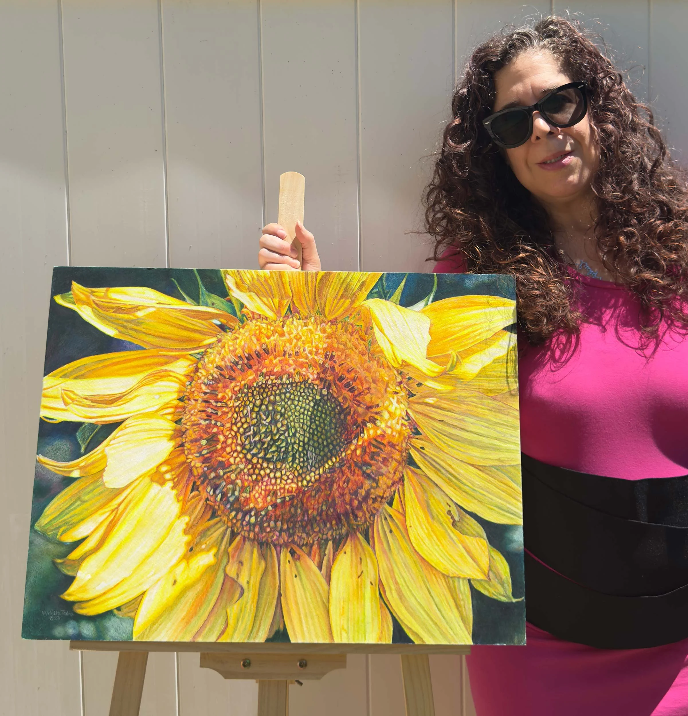Melissa Tobia, full-time botanical artist, standing beside one of her finished floral paintings.