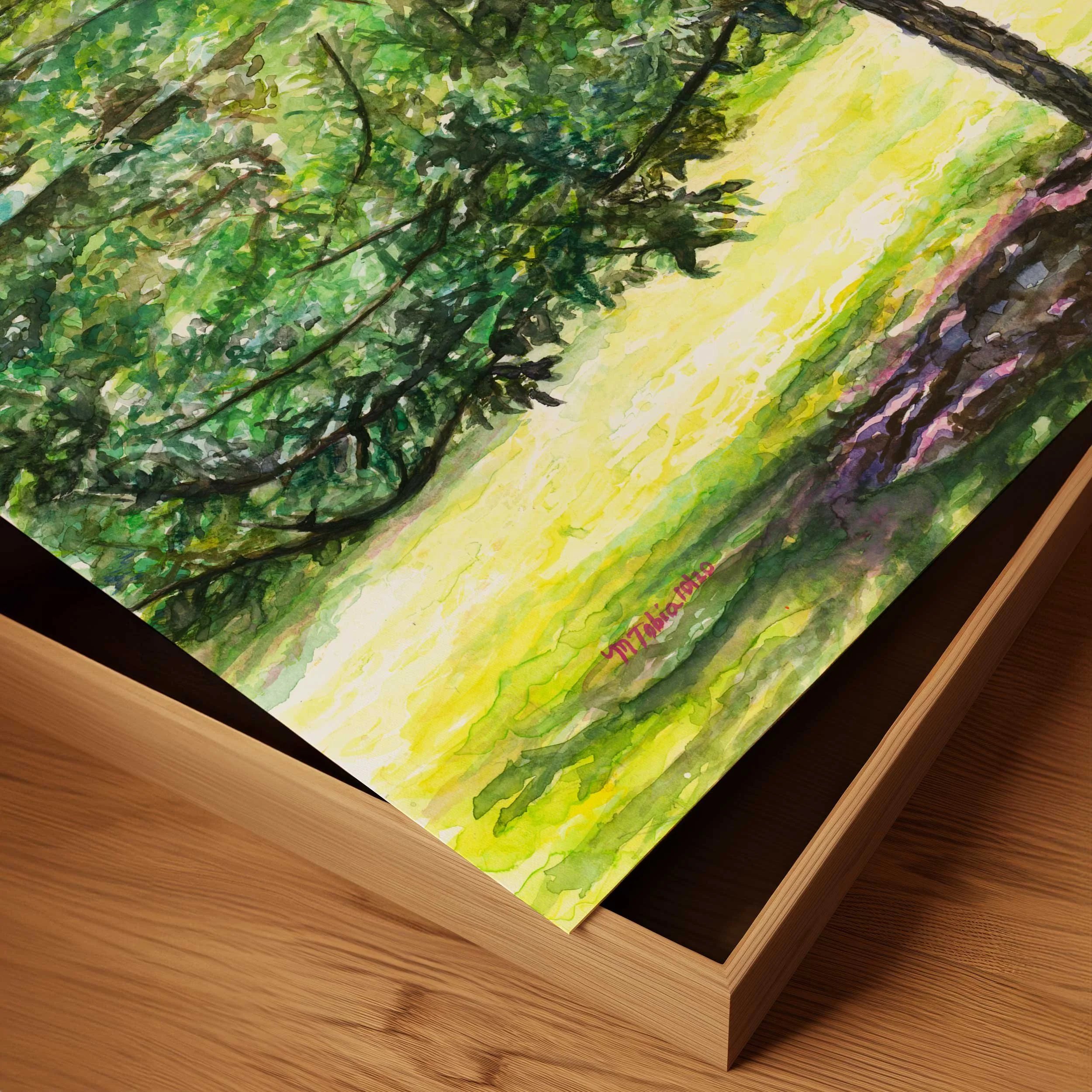 Corner detail of the watercolor tree painting showing the paper edge on a wood table