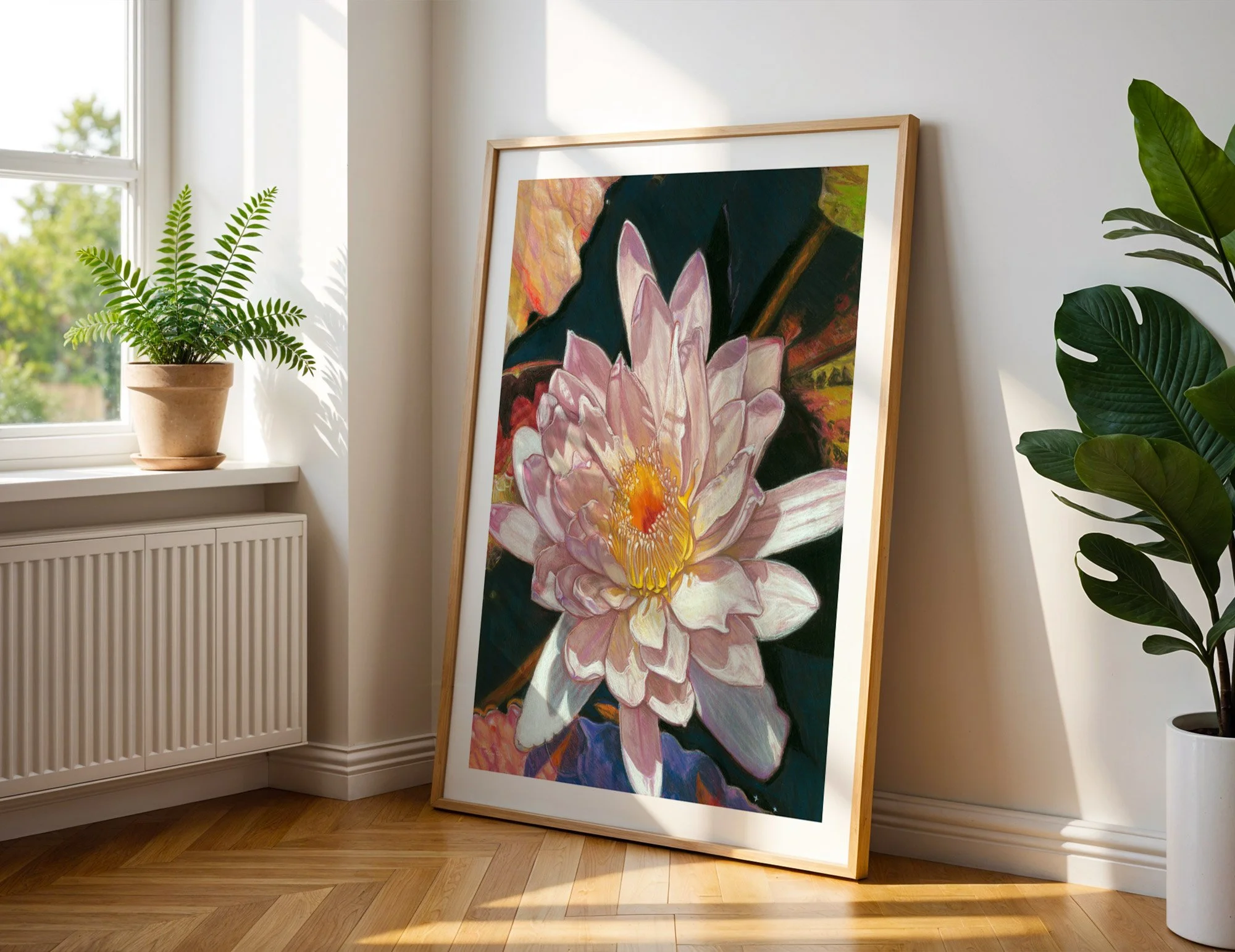 Water lily art print in light wood frame leaning against a white wall on herringbone wood floor beside a potted fern