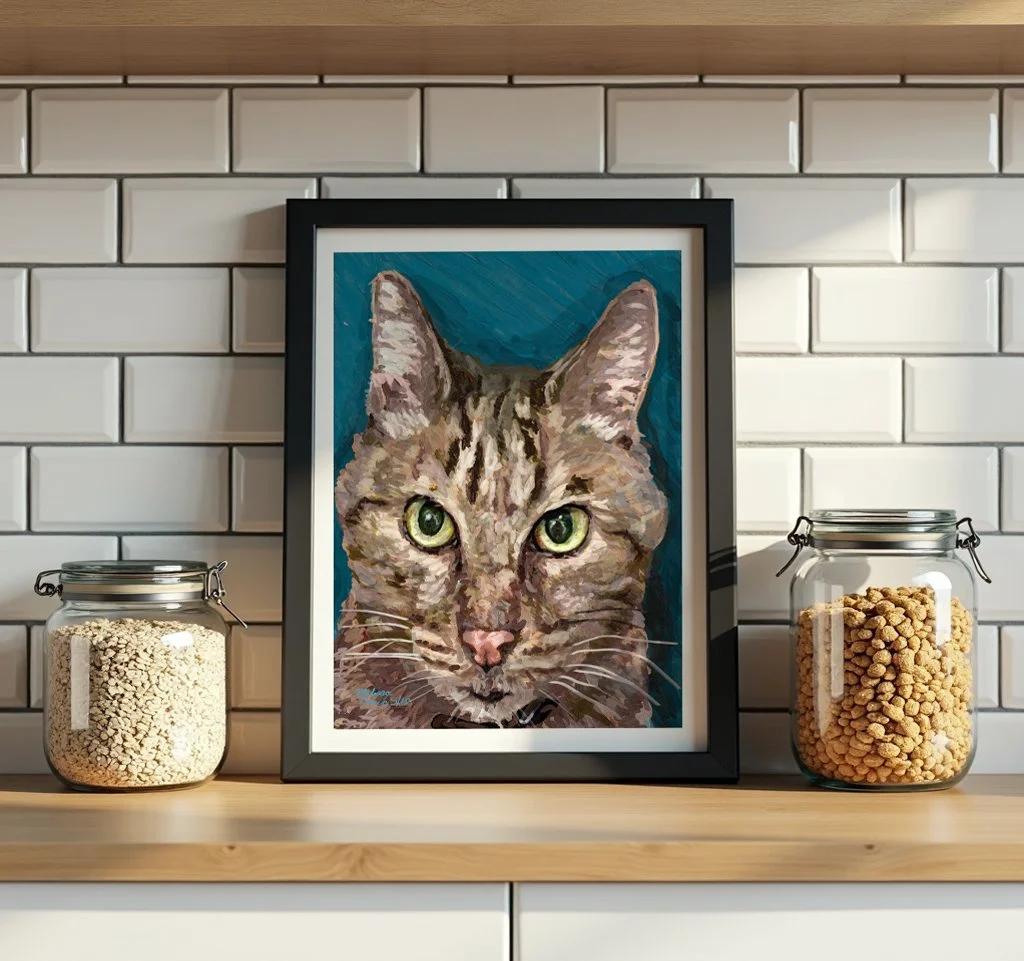 Tabby cat wall art in a black frame on a white subway tile kitchen shelf with glass jars