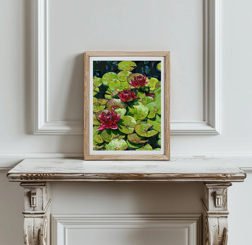 Red water lilies print in a light wood frame hung above a white marble mantelpiece