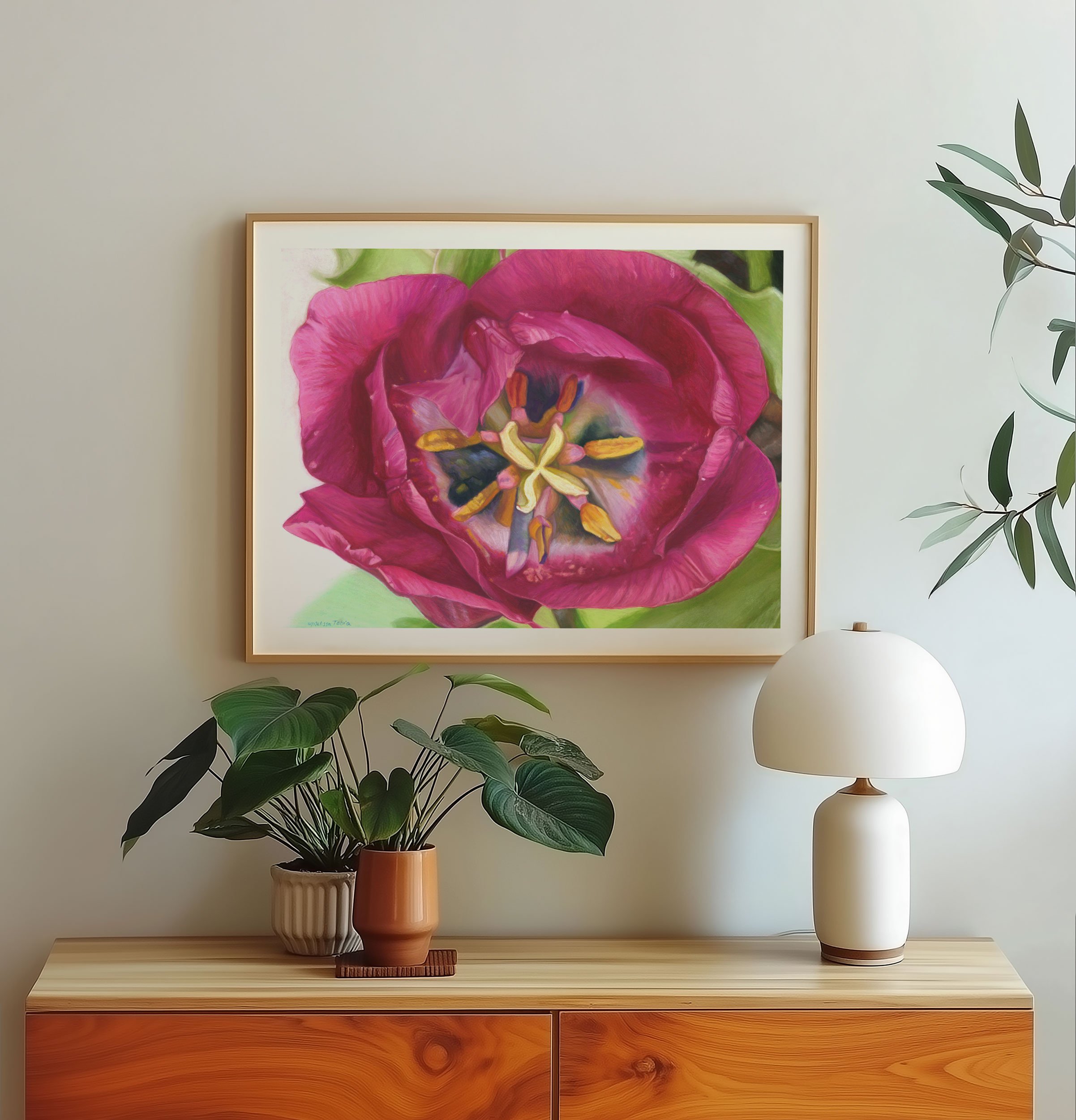 Framed tulip print on a wall above a wood console with a mushroom lamp and trailing plant