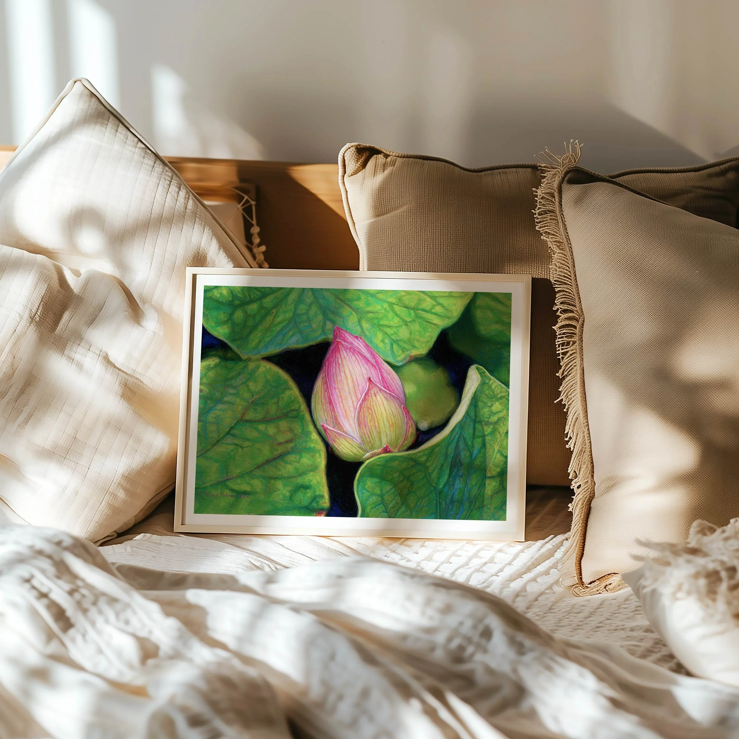 Pink Lotus fine art print in wooden frame against pillows on bed