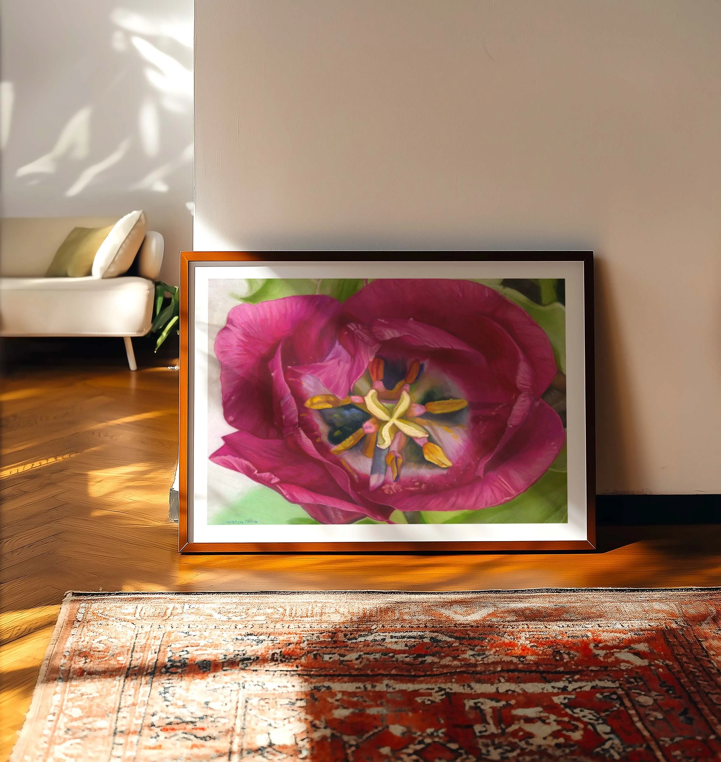 Tulip wall art in a light frame leaning on a wood floor beside a sofa and patterned rug