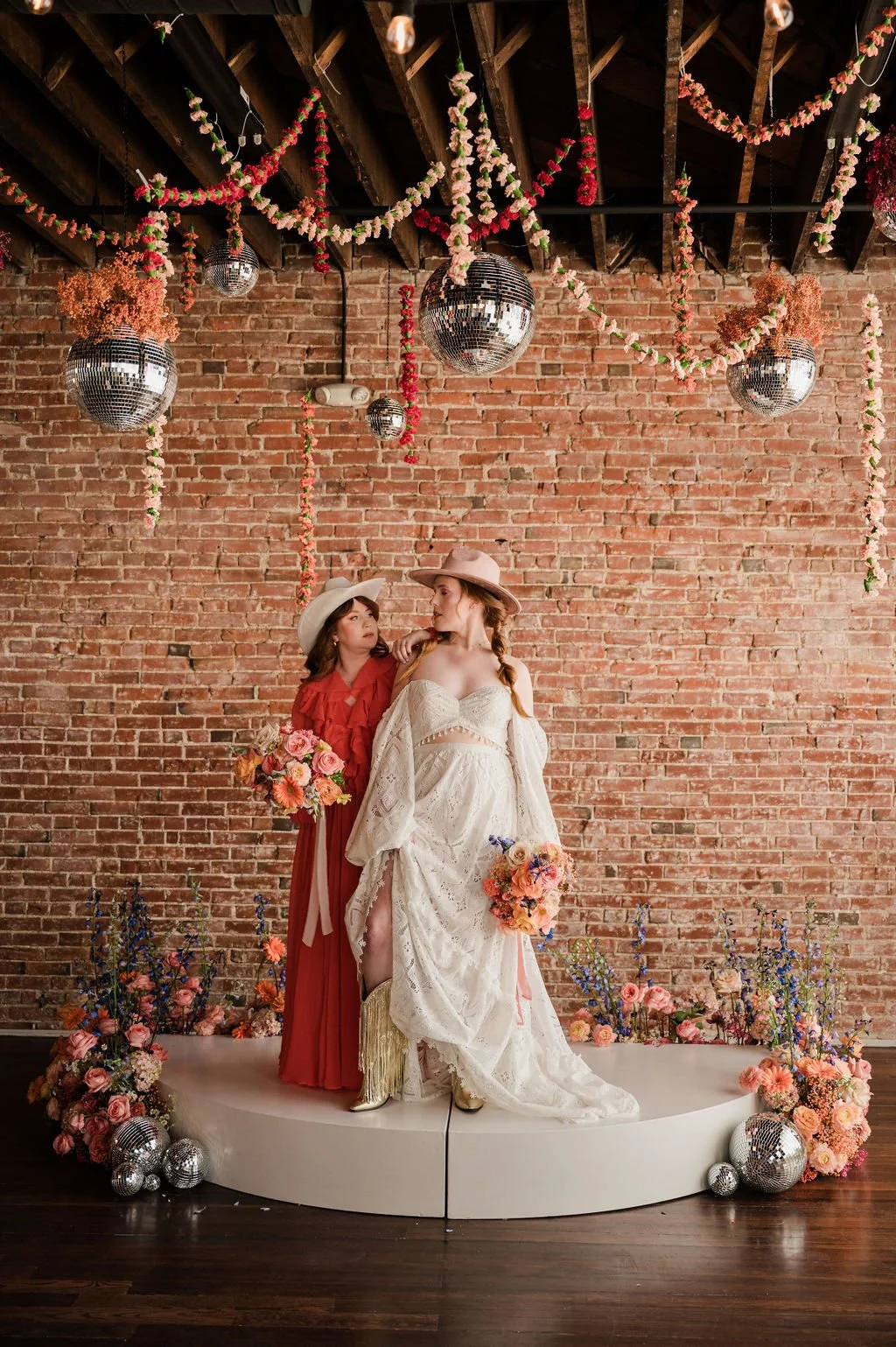 couple standing under disco ball and floral installation