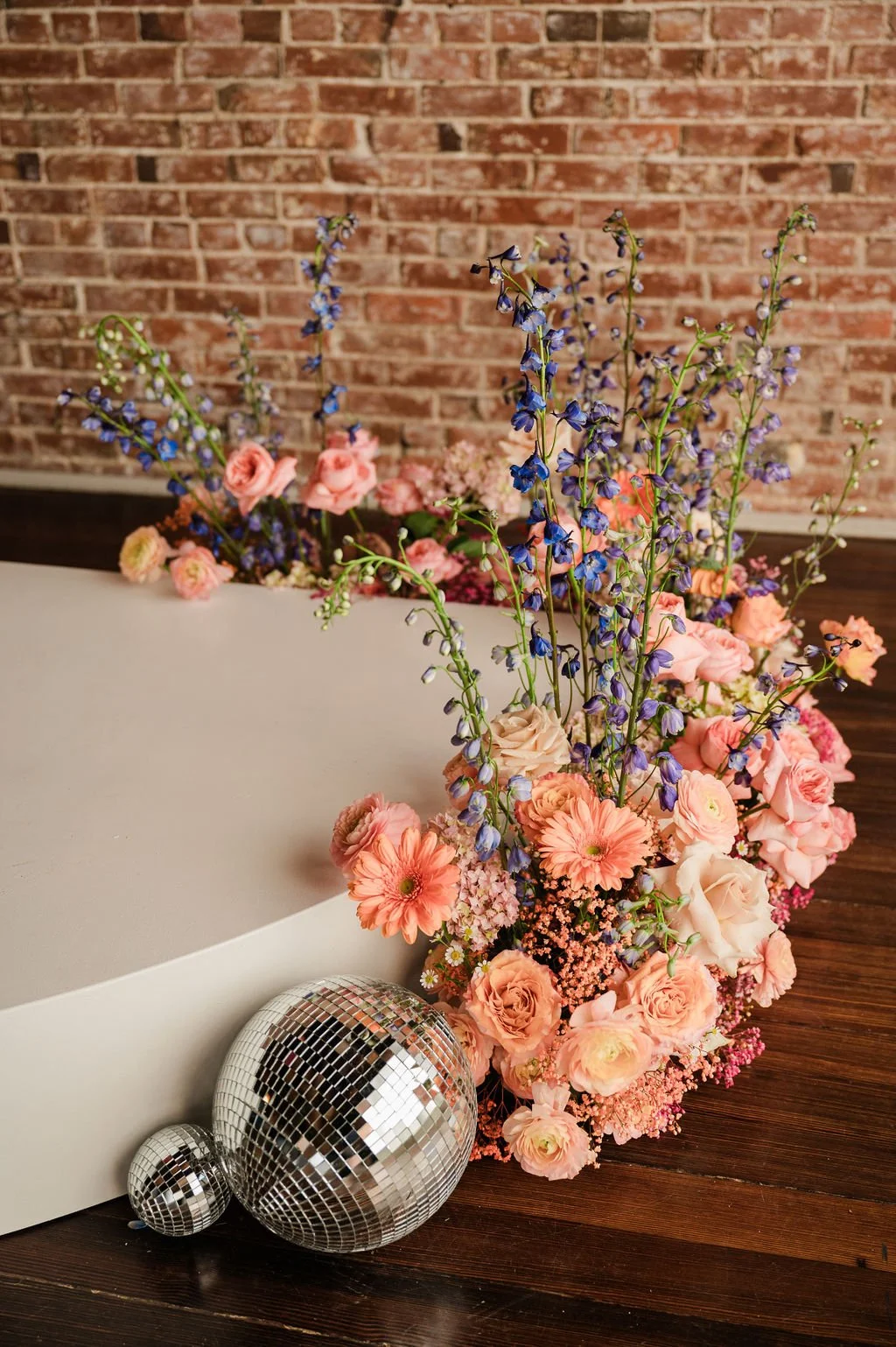 floral installation in front of round stage with disco balls