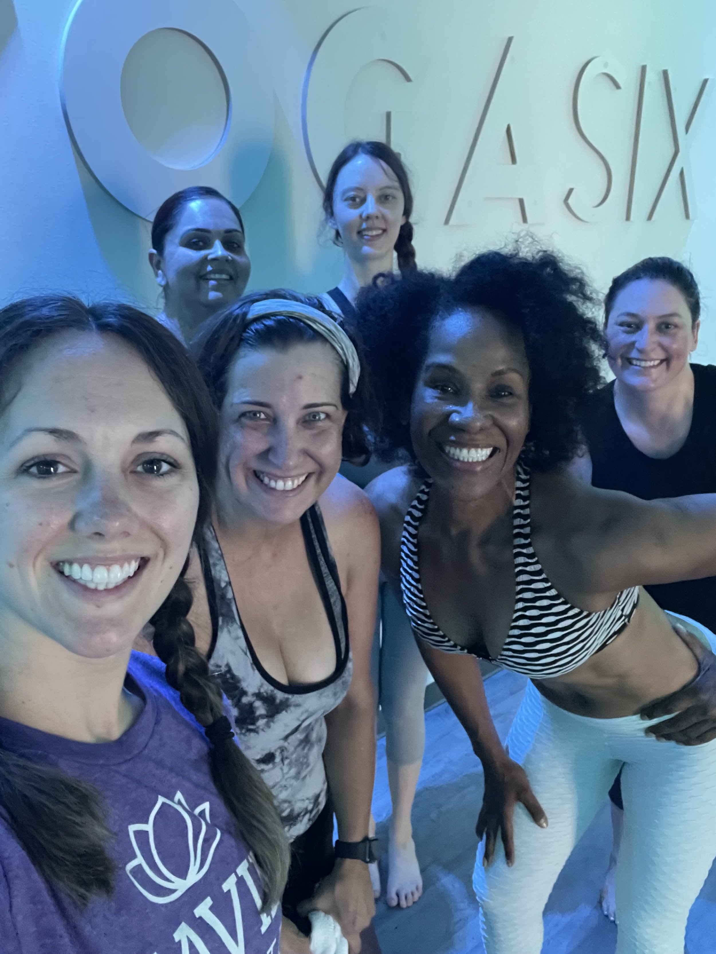 Group of women smiling in a yoga studio.