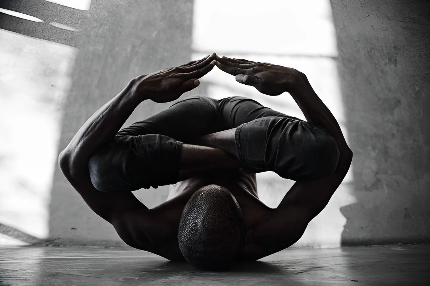 A person practicing yoga indoors, performing a headstand while holding their legs crossed behind their head, with natural light coming through a window.