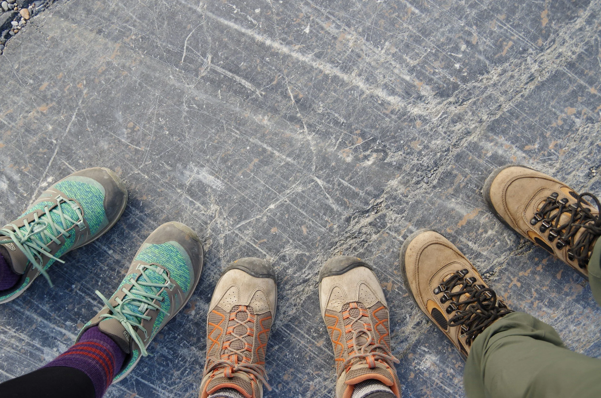 Three pairs of feet wearing walking boots