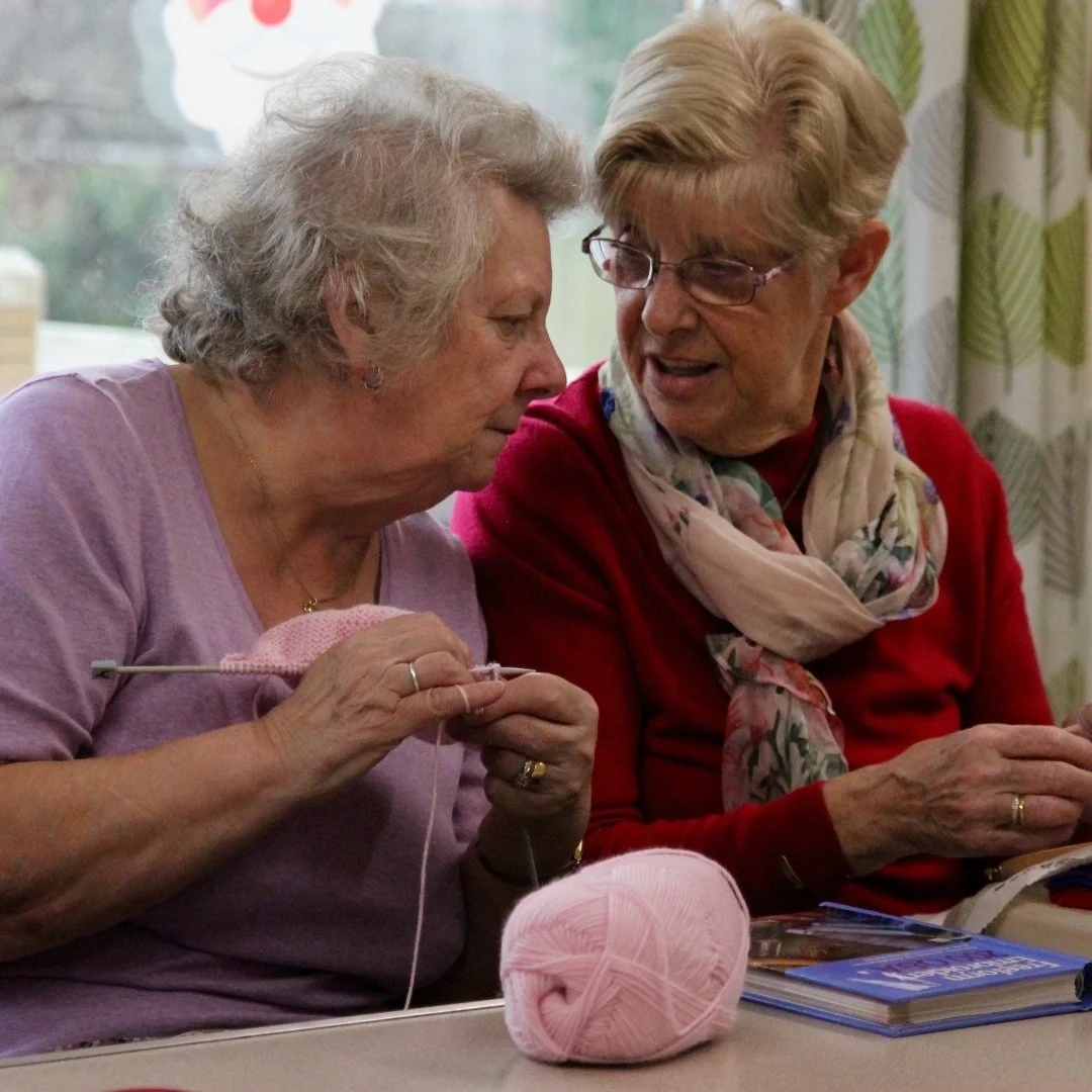 Two ladies having a conversation whilst knitting