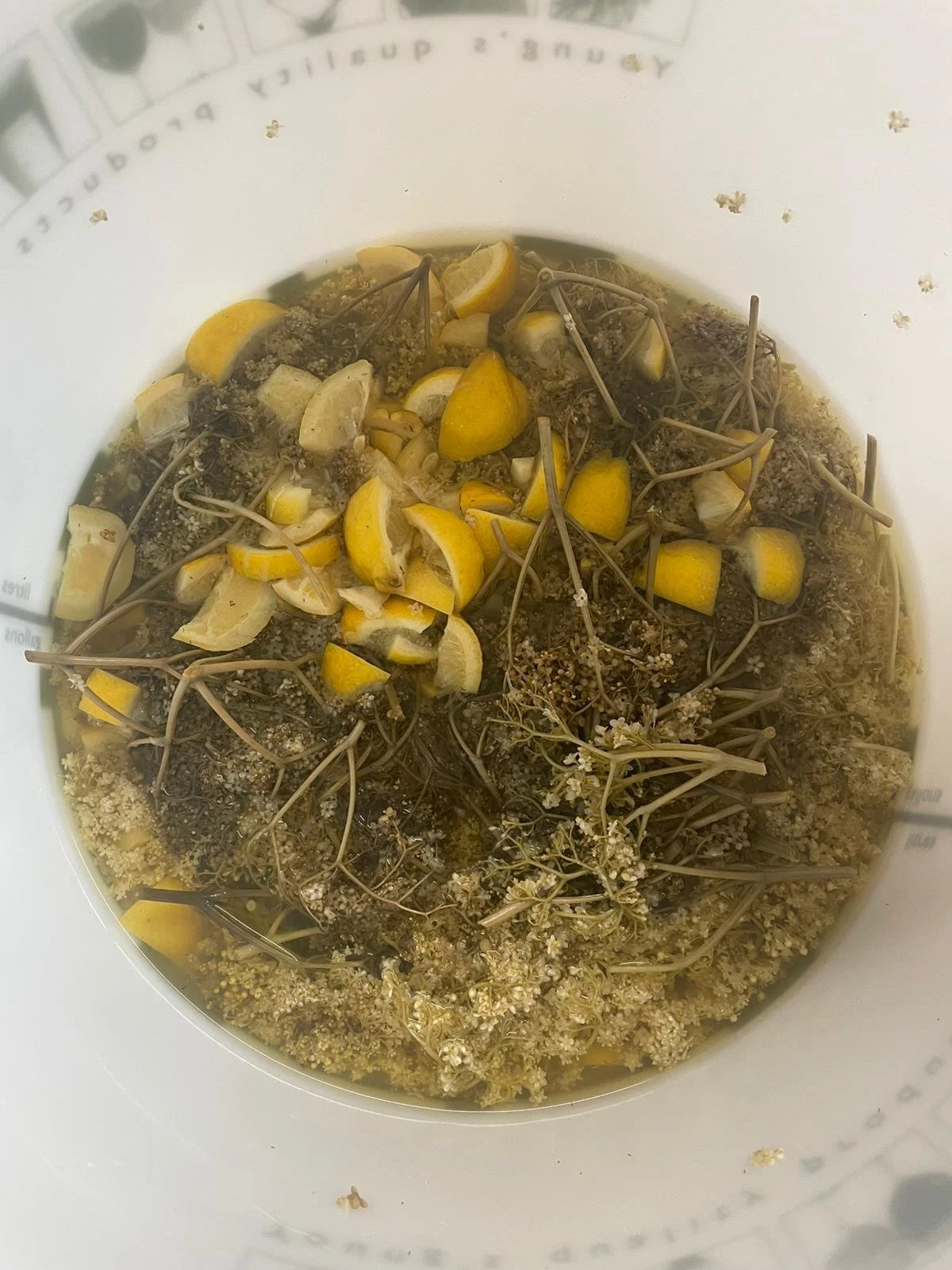A mix of elderflower foliage and lemon pieces in a large container