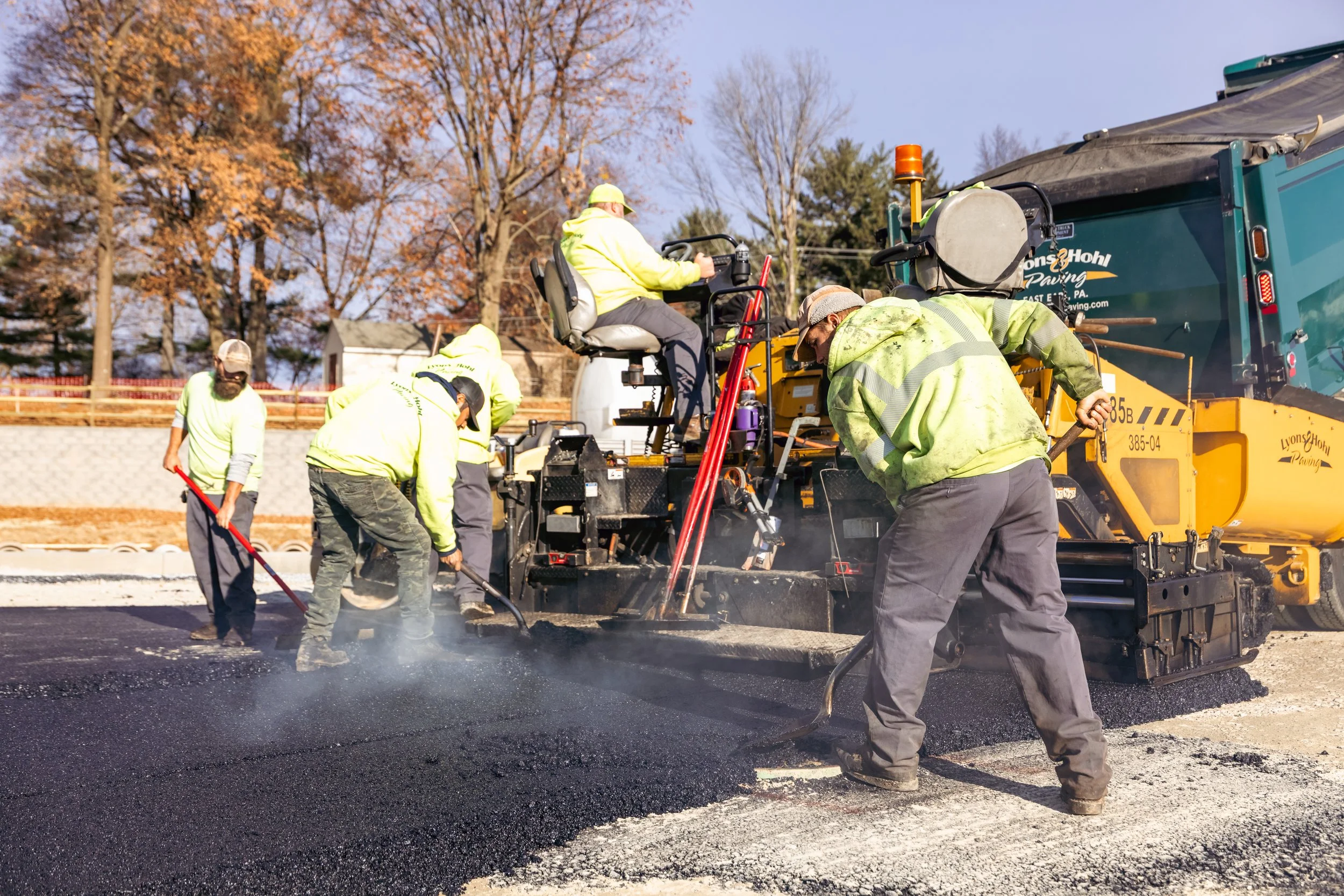 Lyons & Hohl Paving crew laying fresh asphalt on a residential driveway, ensuring a smooth and durable surface for homeowners.