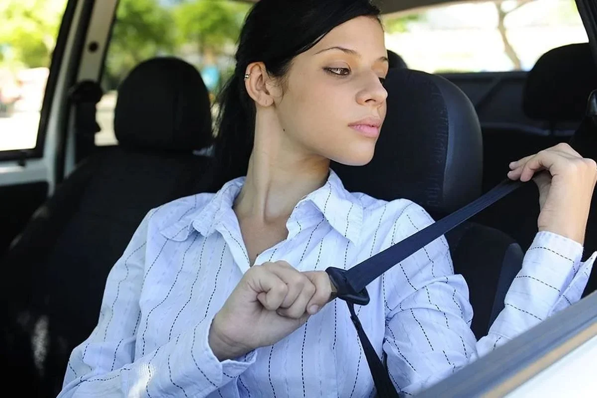 Driver fastening her seat belt in a car