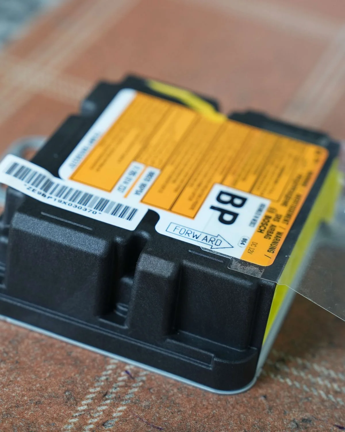 Close-up of an SRS airbag control module and its part label