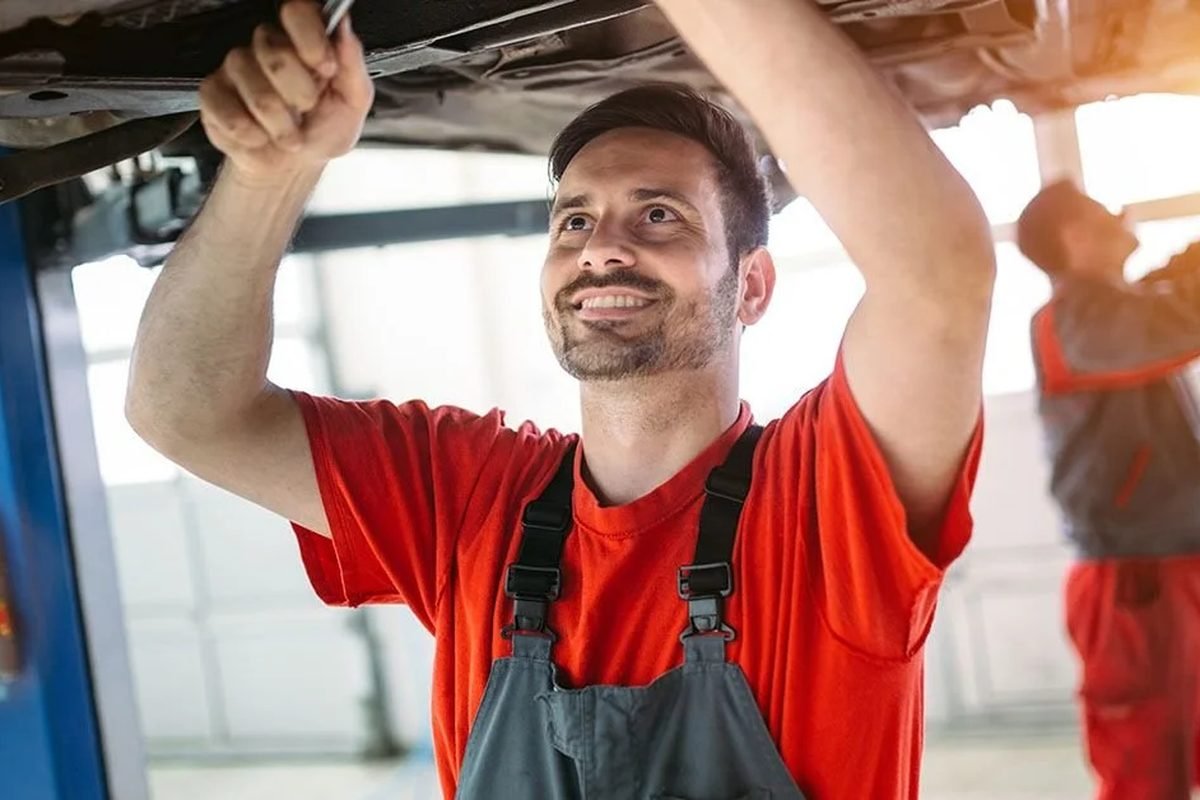Mechanic working under a car raised on a lift
