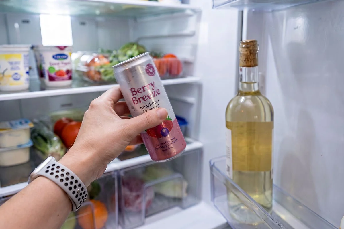 Grabbing an RTD cocktail from a fridge.