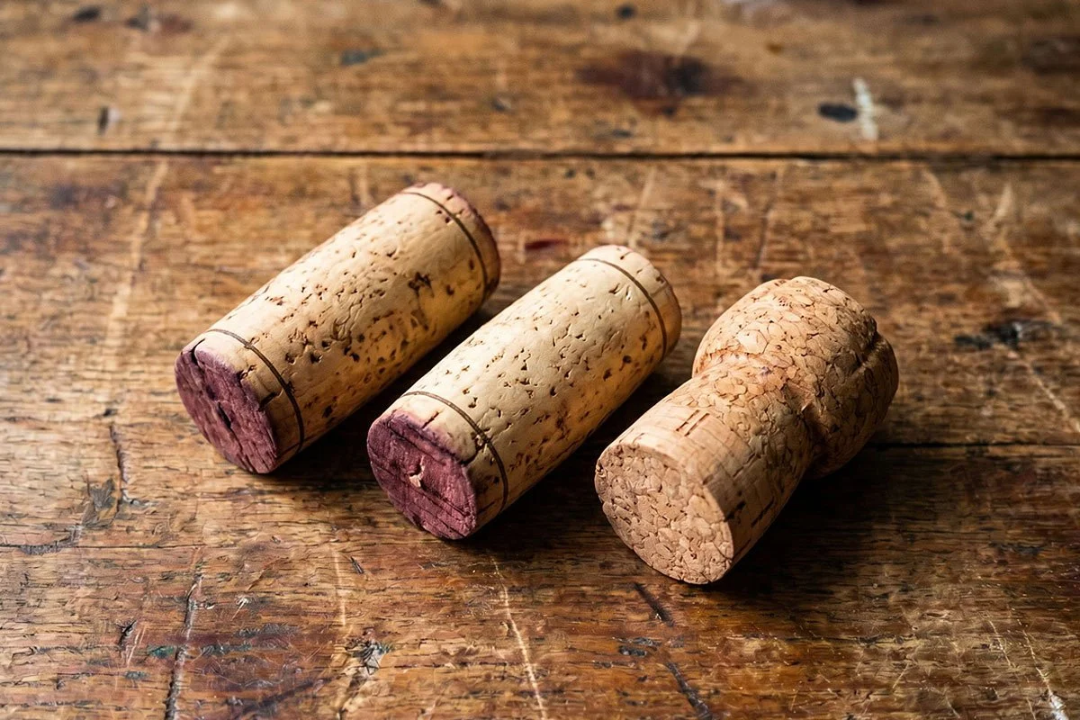 Three wine corks on a table.