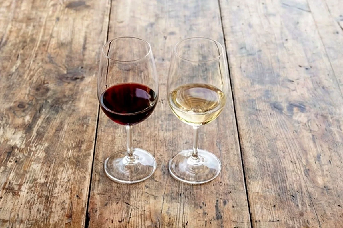 Red and white wine glasses on a winery patio table.