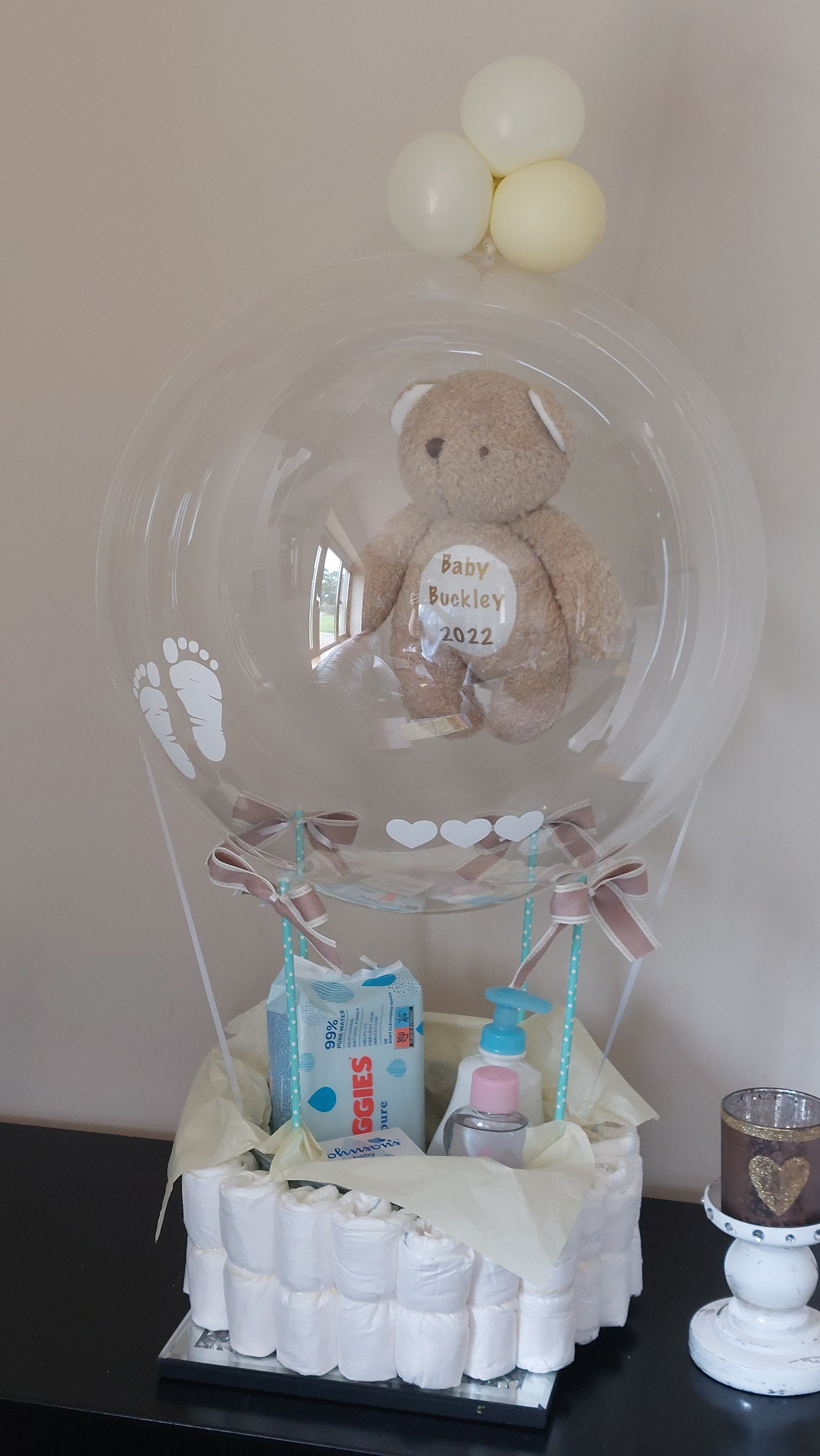 ITEM #34
€60 (price may vary)
Hot air balloon inspired balloon display with basket surrounded with nappies and customizable baby supplies. Also includes a personalised teddy bear.