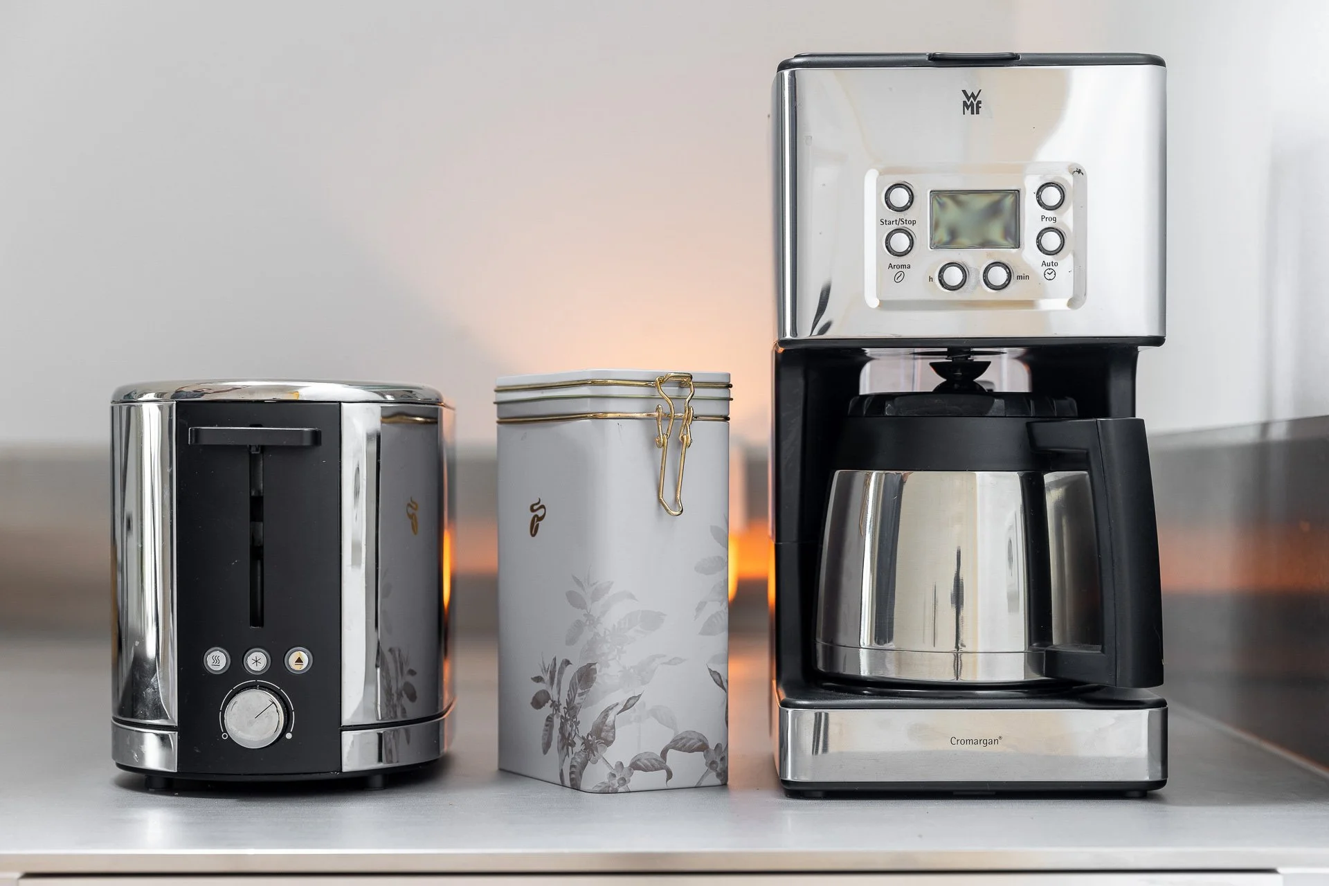 Toaster, Kaffeedose und Kaffeemaschine auf einer Küchenarbeitsplatte.