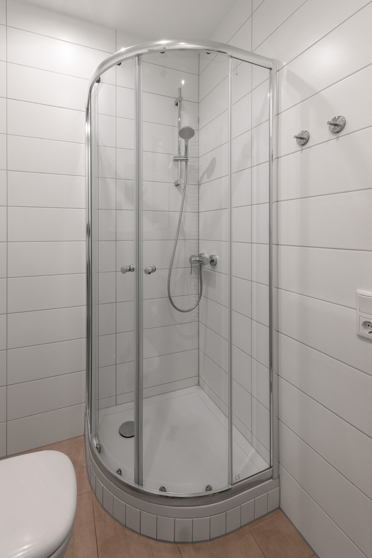 Eckdusche mit Glaswänden und Fliesen in einem modernen Badezimmer.