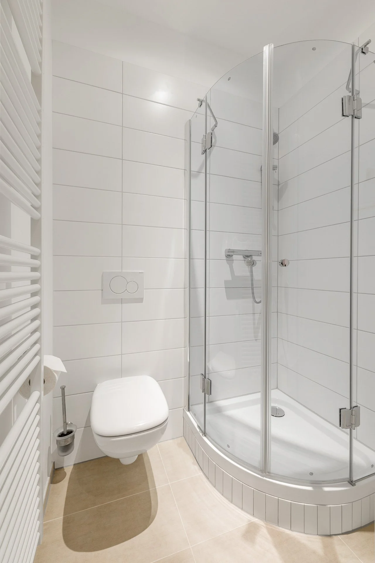 Modernes Badezimmer mit Duschkabine, hängender Toilette und Handtuchheizkörper.