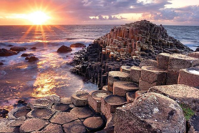 Sunset over Giant’s Causeway in Northern Ireland, with golden light reflecting on the North Atlantic and hexagonal basalt columns in the foreground.