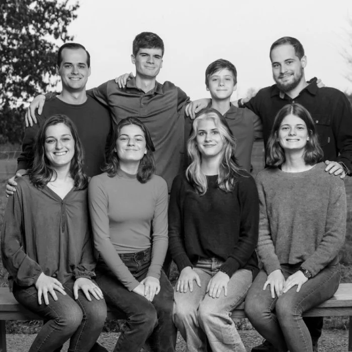 8 young people posing and smiling together.