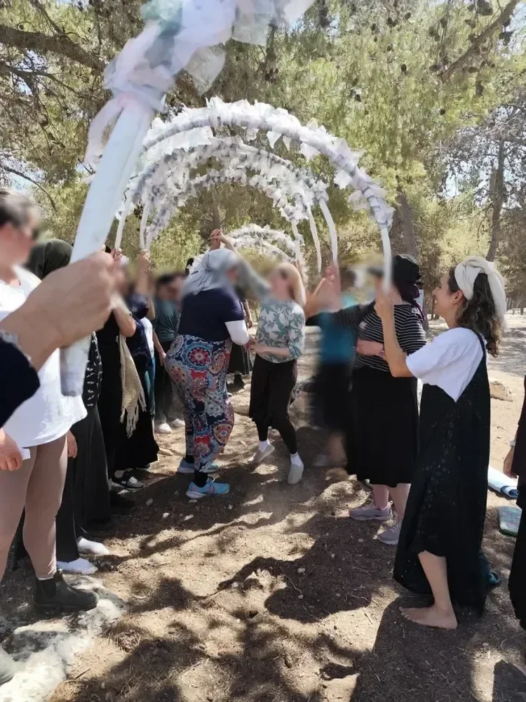 Community group gathered beneath a handmade outdoor canopy.