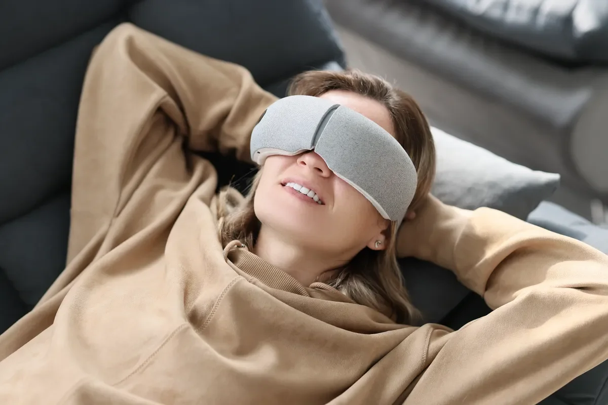 Person wearing an eye mask while resting during a ketamine assisted psychotherapy session.