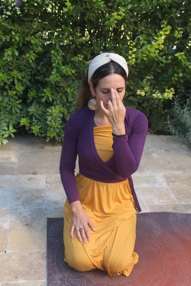 Ruthie Ayzenberg practising a calming breathwork technique outdoors.