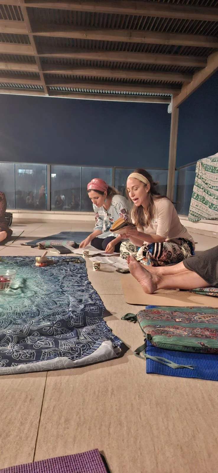 Two women leading a seated community workshop indoors.