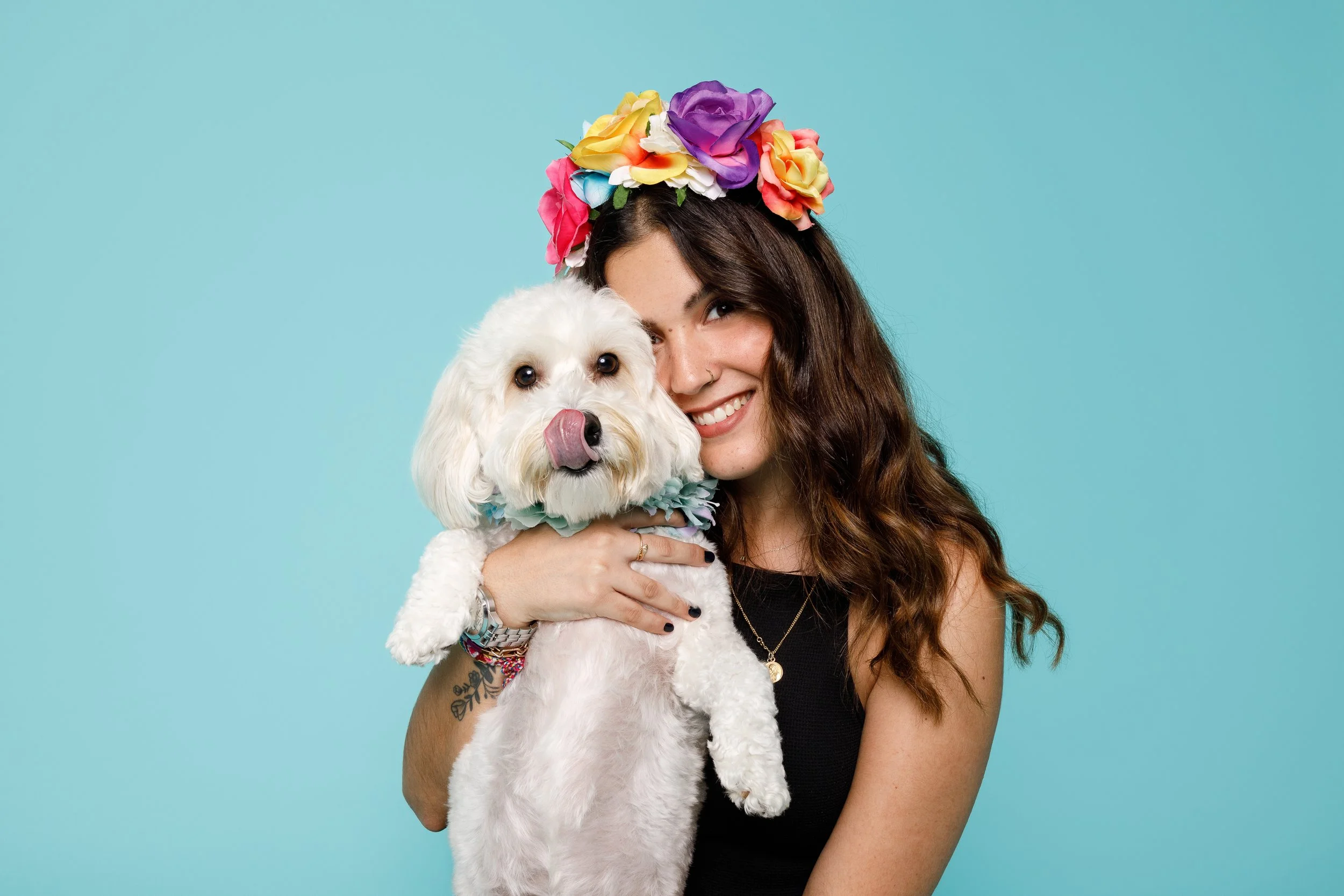 rapariga com coroa de flores com cão branco em fundo azul 