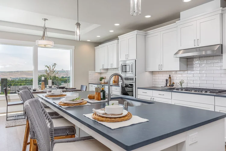 White kitchen with a large island and pendant lights
