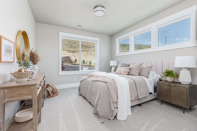 Primary bedroom with an upholstered bed and natural light