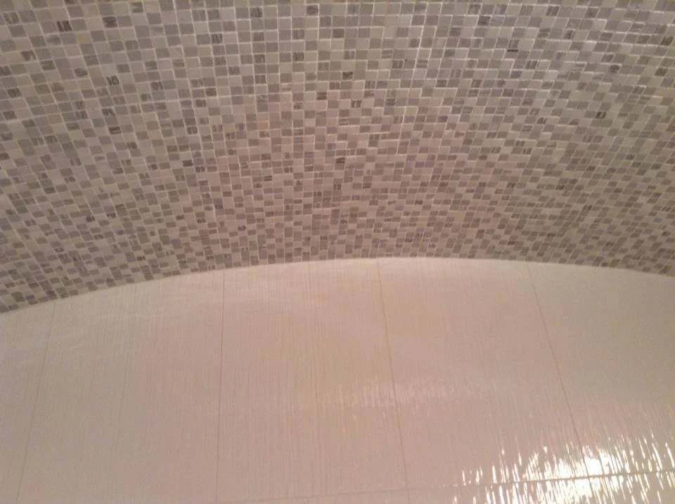 Close-up of a tiled surface with small square mosaic tiles in shades of brown and beige.