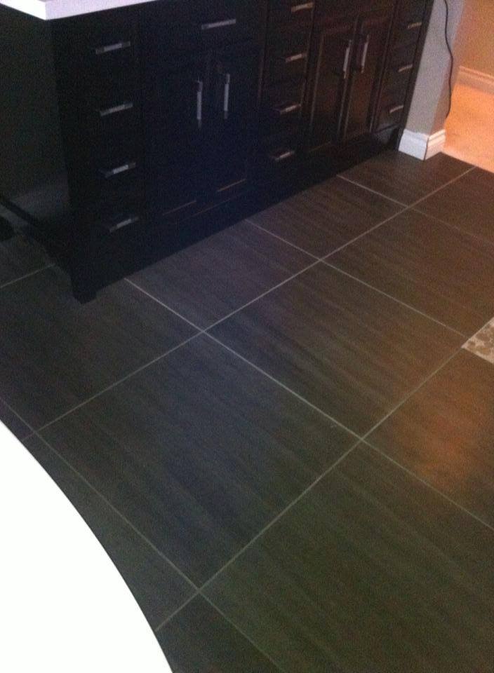 Kitchen with dark wood cabinetry, black countertops, and dark tiled floor.