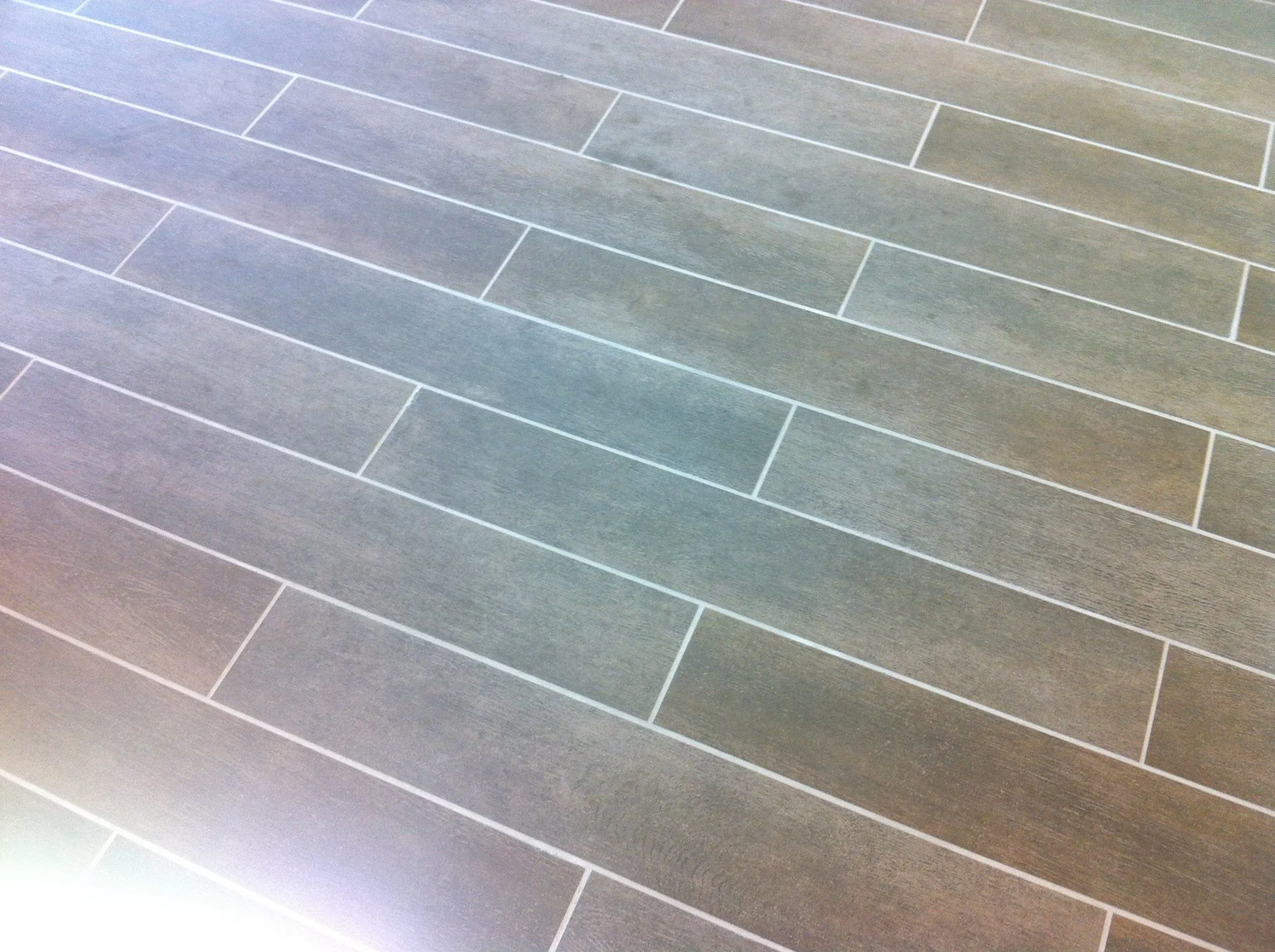 Gray rectangular tile flooring arranged in a staggered pattern.