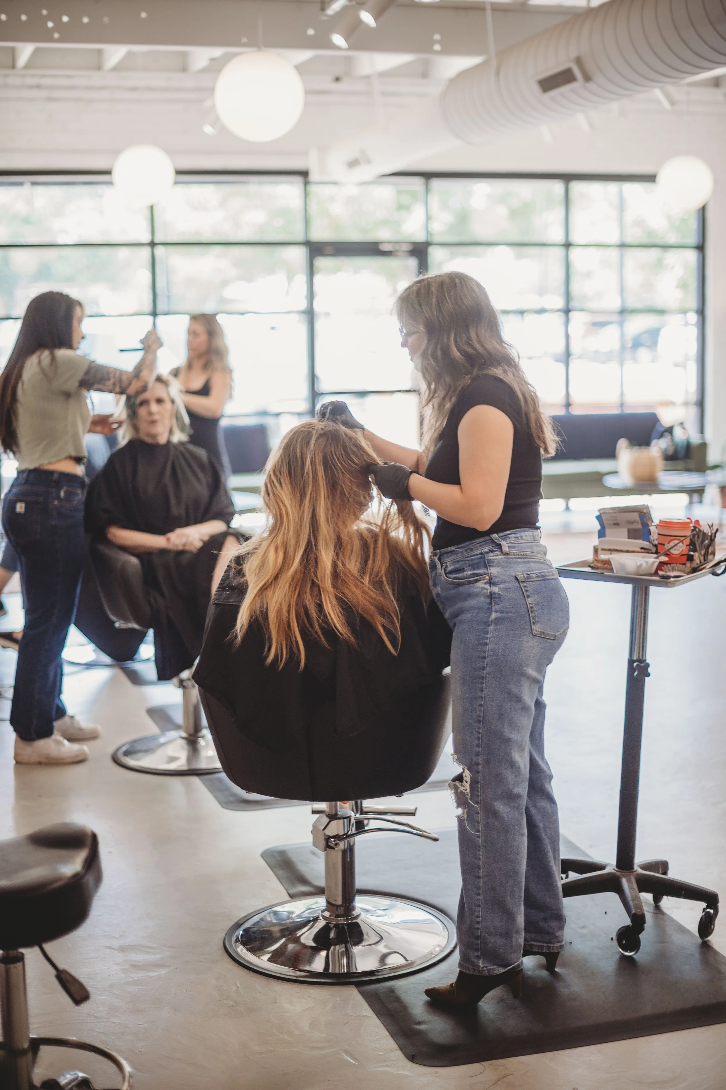 Person mixing white powder with a hand whisk in a measuring bowl, wearing a floral dress and red nail polish.