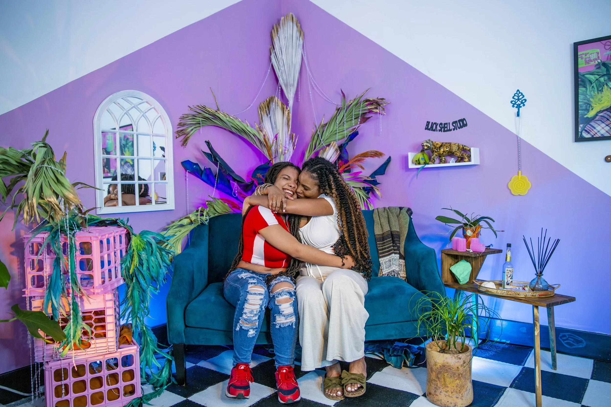 Mother and daughter hugging on a colorful couch 