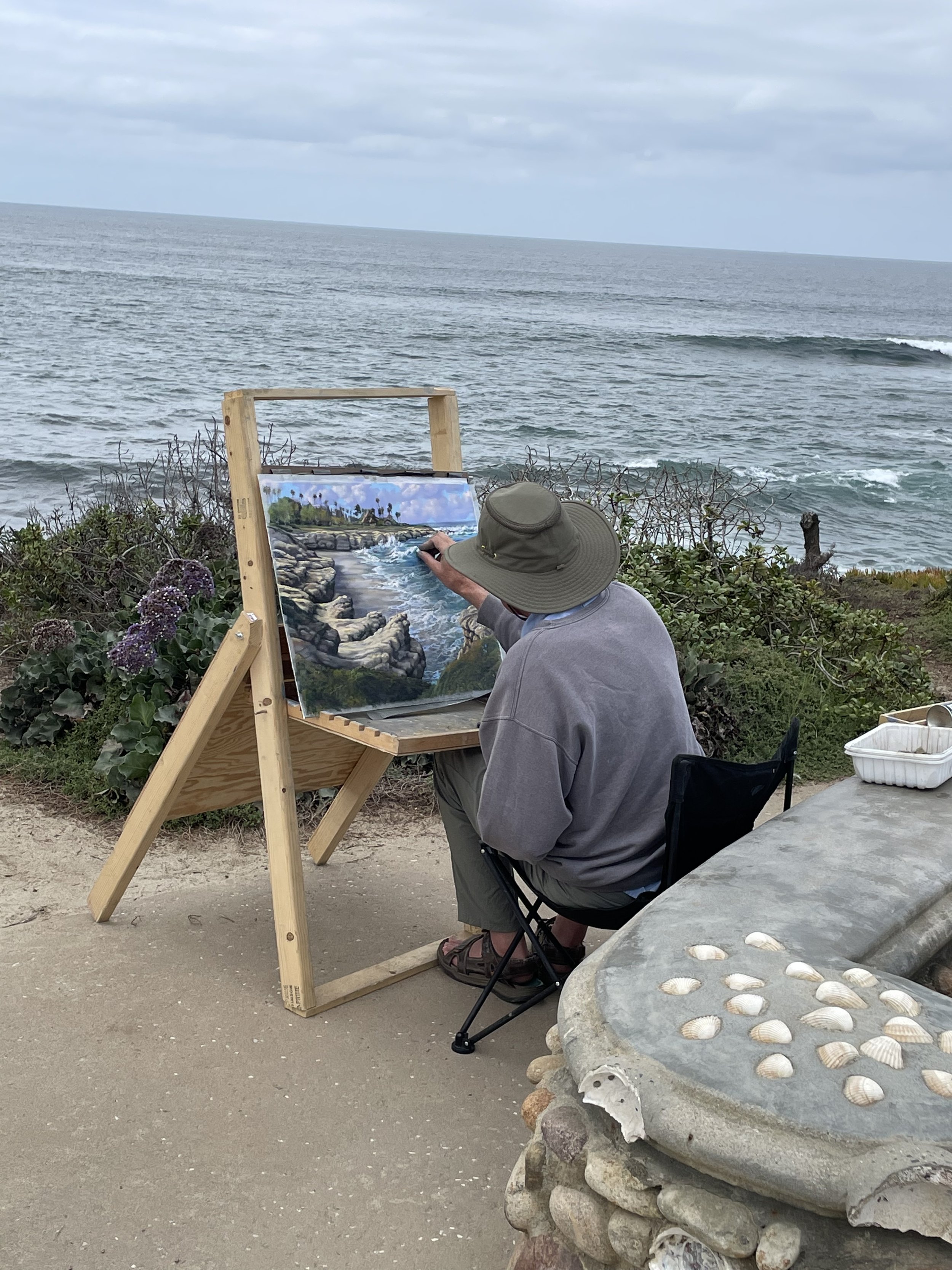 That's me, "plein aire" painting in La Jolla. Photo taken by an out-of-state gentleman from who strolled by as I was painting along Shell Beach. He bought this one before it was complete. He flew home, and I then shipped it to him in New York. Th