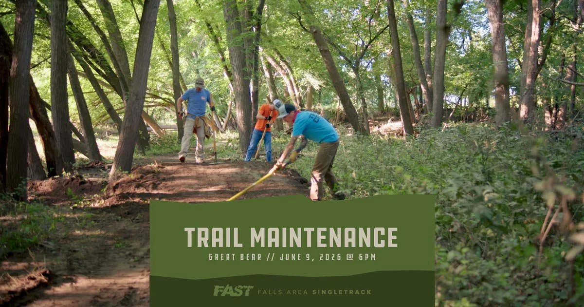 A trail crew group moving dirt in a forested area.