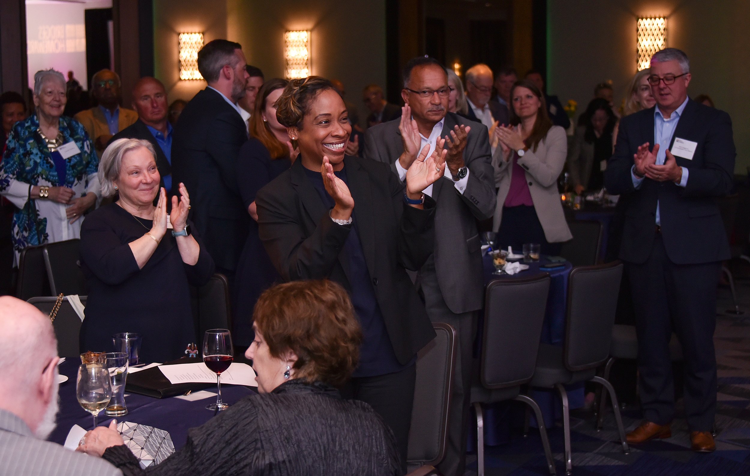 Massachusetts Child Advocate Maria Mossaides, Attorney General Andrea Campbell, and others stand and applaud Bob Gittens.