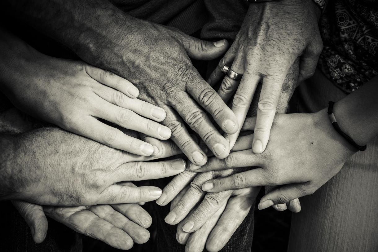 Old and young hands placed on top of each other.