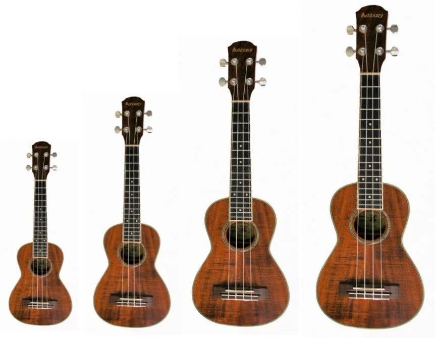 Four different sized ukuleles in a row.