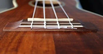 Close up of a tie bar ukulele bridge.