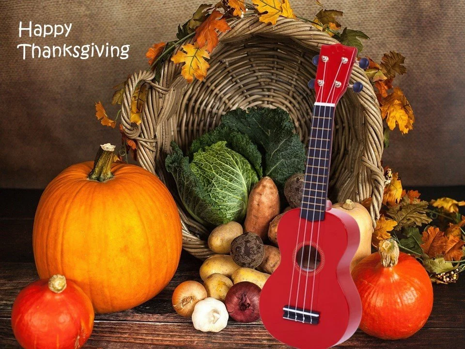 Red ukulele with basket of thanksgiving vegetables.